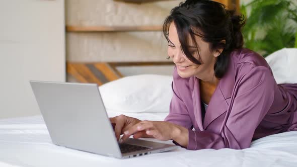 Middle Aged Woman in Front of a Laptop Monitor in Bed alt