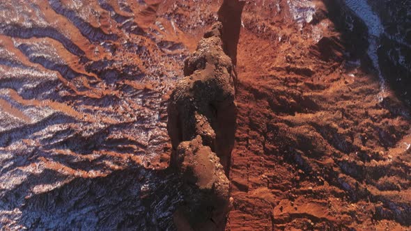 Top Down Narrow and Tall Red Cliffs Rising High at Red Desert Covered By Snow alt