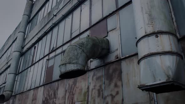 Facade of an Abandoned Workshop of a Large Enterprise and Large Ventilation Pipes