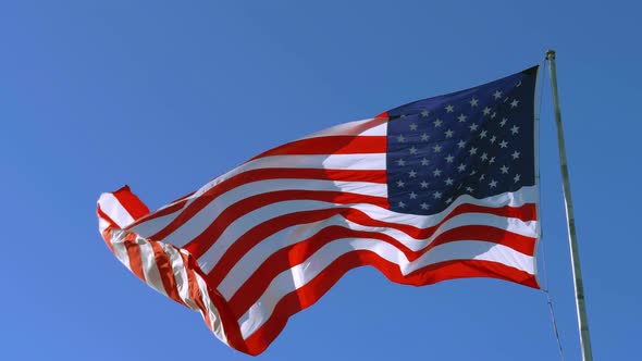 American Flag Blowing in the Wind with a Blue Sky alt