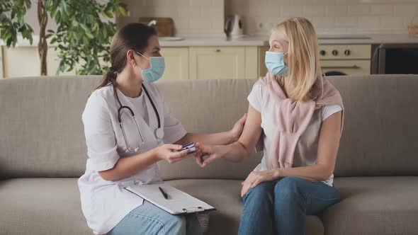 Woman Nurse in a Medical Mask Help Middle Aged Woman During During Illness or Pressure Female Doctor alt