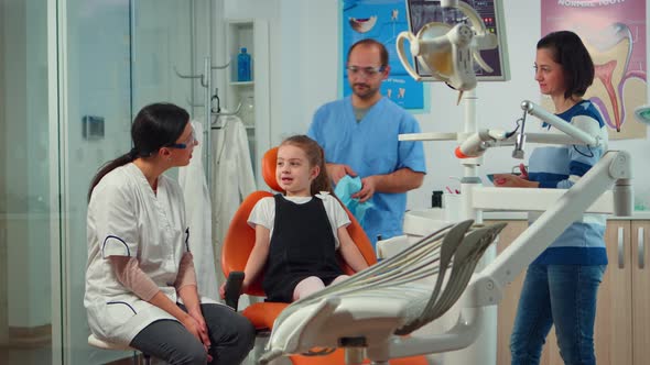 Little Girl Patient with Tooth Pain Explaining Dental Problem To Pediatric Dentist alt