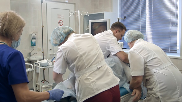 Team of doctors and nurses preparing patient for gastroscopy