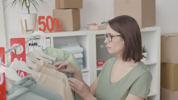 Woman Choosing Clothes in Shop alt