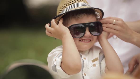 Caring Parent Pulling the Headwear Off His Son Face