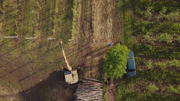 Excavator Drives Concrete Poles Into the Ground