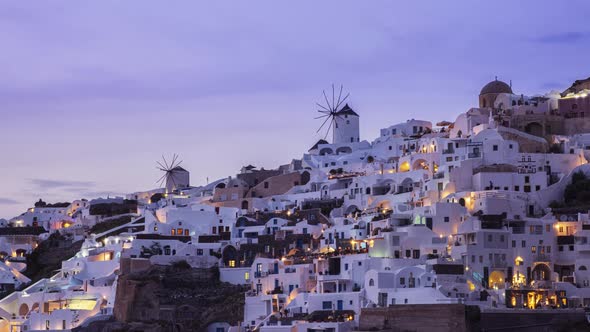 Colorful view of Oia village and windmills on Santorini island at dusk, timelapse
