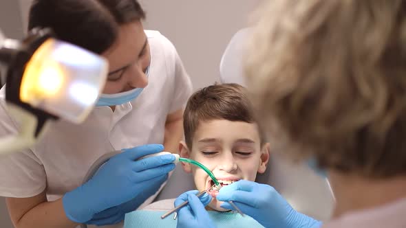 A little boy treats his teeth, two dentists examine the child's teeth, concepts about dentistry alt