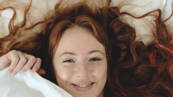 happy woman wakes up in the morning in the bedroom on a pillow