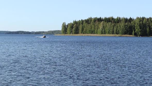 Clear water of finnish lake with trees and boat