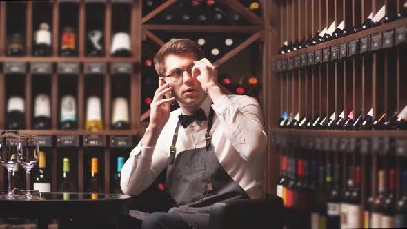 Elegant Young Sommelier in a Wine Boutique Makes Online Sales alt