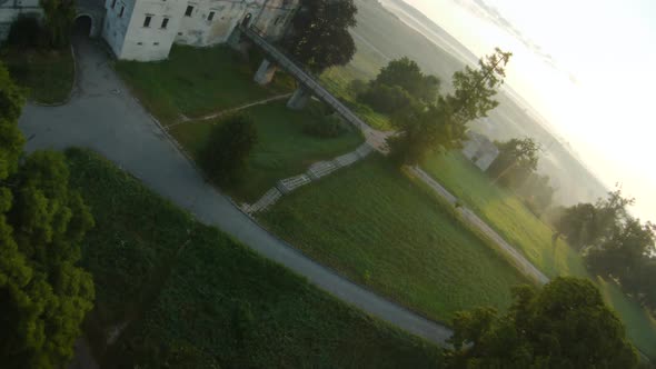 Colorful Hot Air Balloons Fly Over the Medieval Castle and Lake in the Morning Fog. Maneuverable alt