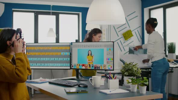 Retoucher Putting on Headphones Retouching Image Using Stylus Pen alt