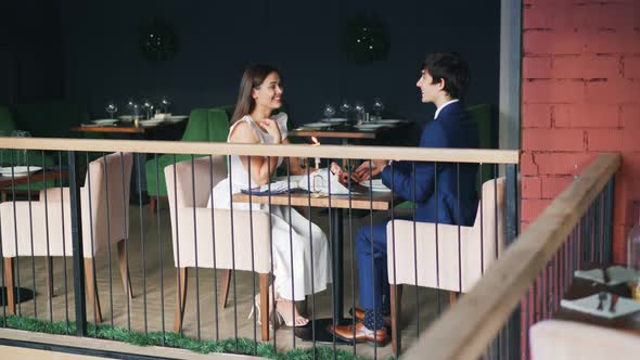 Beautiful Couple Man and Woman Are Enjoying Date in Restaurant alt