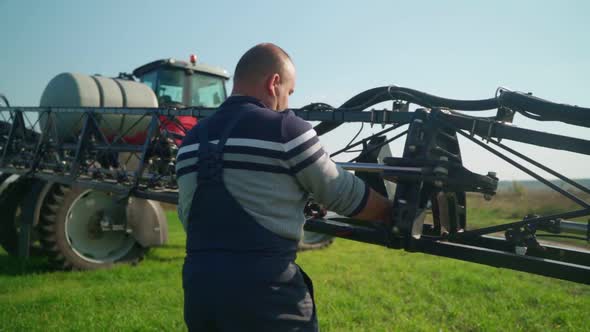 Farmer Prepares an Agricultural Sprayer for Work alt