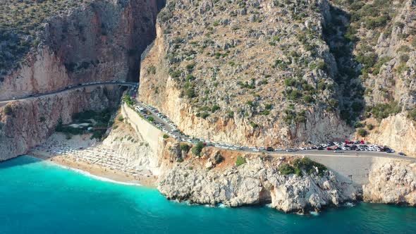 aerial drone panning out revealing a coastal road at Kaputas Beach in Kas Turkey on a sunny afternoo alt