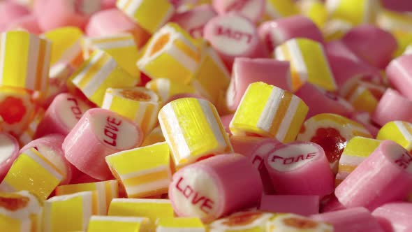 Colored Striped Caramel Candies with Inscription Love Rotating Shot alt