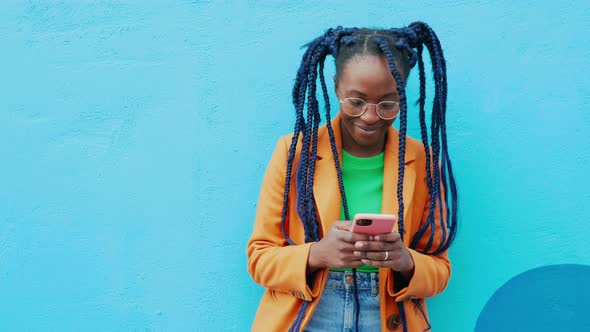 Portrait of woman with long black braids holding smart phone, Milan, Italy