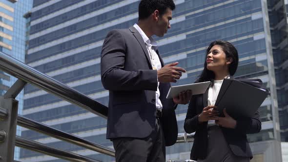 Young Indian businessman talking with businesswoman