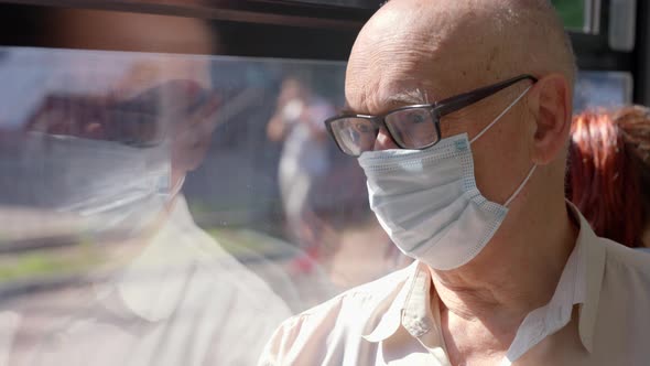 Senior Man Wearing Mask to Prevent COVID19 Infection During Bus Ride