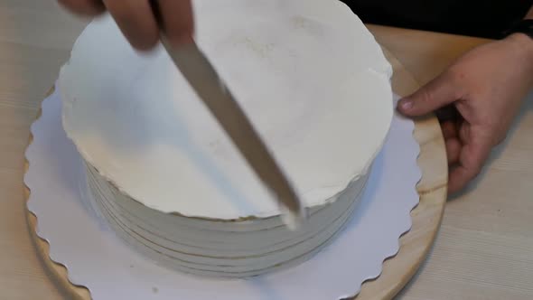 Top View Smoothing the Cream on a Biscuit Round Cake with a Special Spatula