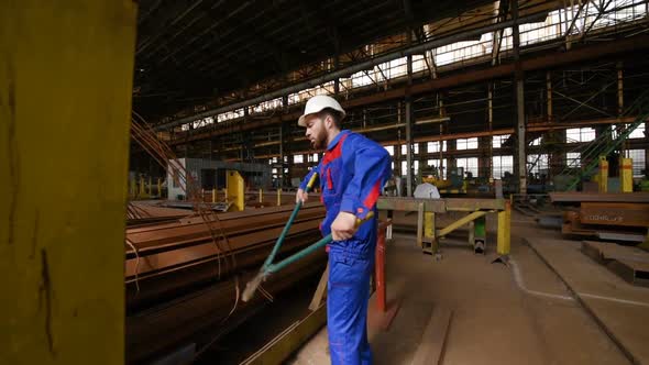 Worker in a White Helmet Bites the Steel Wire with Wire Cutters alt