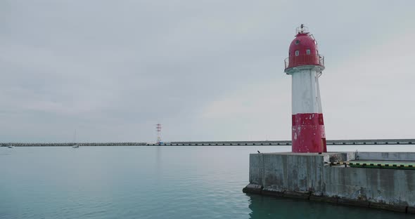 View on Lighthouse with Red and White Stripes From Moving Boat alt