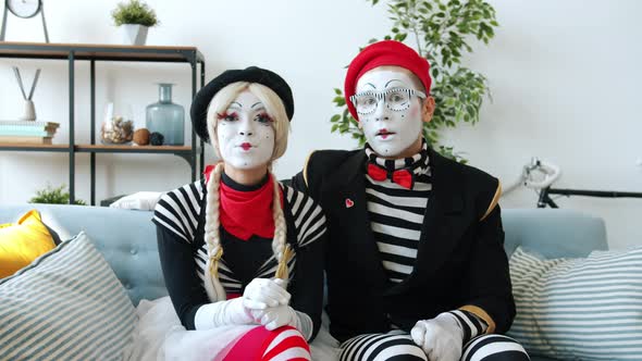 Moody Girl Mime Being Happy and Thankful After Getting Present From Guy While Watching TV at Home alt