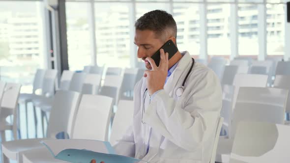 Doctor talking on smartphone at a seminar alt