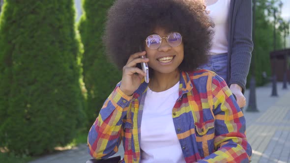 African Woman with an Afro Hairstyle Disabled in a Wheelchair Positive Talking on the Phone in the alt