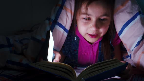 Little Girl Reads Book in Whisper Under Blanket alt