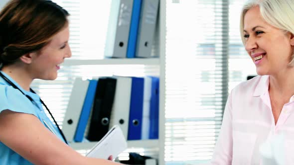 Female doctor giving a medical prescription to a patient alt