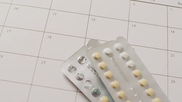 Video of close up of yellow tablets over white calendar alt