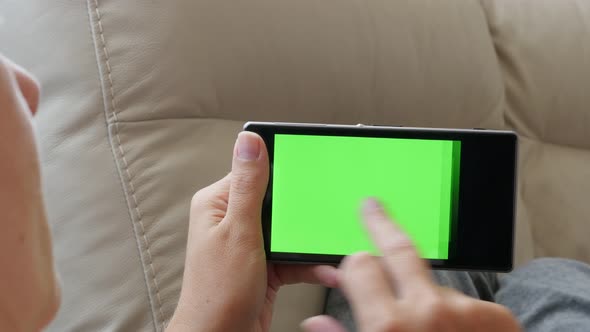 Female relaxing in bed and  surfing on green screen cell phone display 4K 2160p 30fps UltraHD footag alt