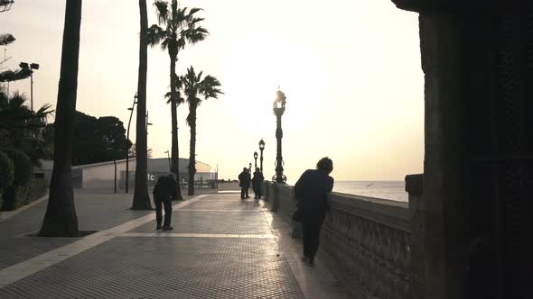 People on a promenade at sunset alt