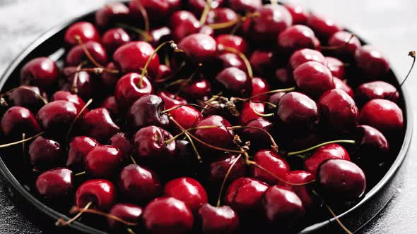 Sweet Fresh Cherry on a Plate on a Stone Background