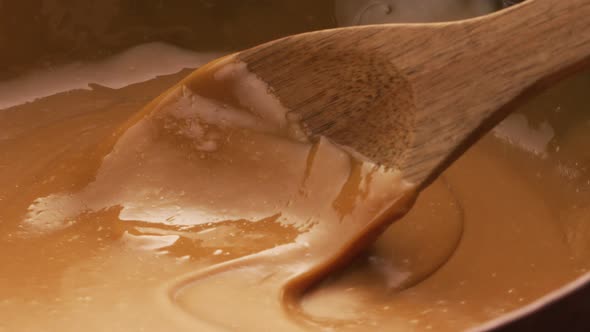 Stirring melted caramel, closeup food shot. 