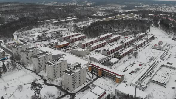 Snow Covered Apartment Buildings Surrounded By Forest Suburb Scene Aerial