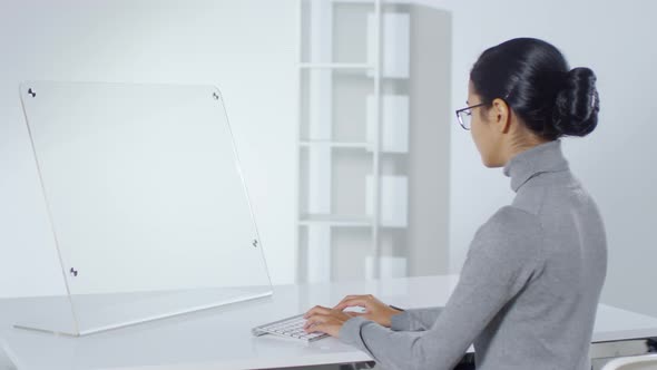 Asian Woman Working on Invisible Futuristic Computer alt