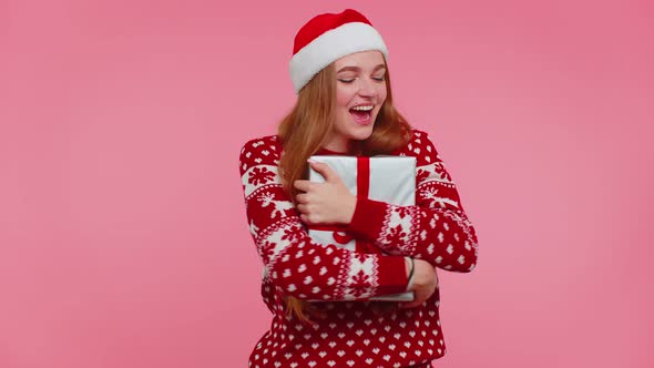 Cheerful Girl in Christmas Santa Sweater Getting Present Gift Box Expressing Amazement Happiness alt