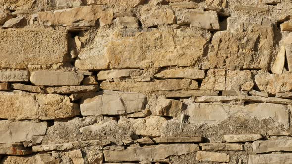 Old house stone wall slow tilt 4K 2160p 30fps UltraHD footage - Close-up of ancient masonry construc alt