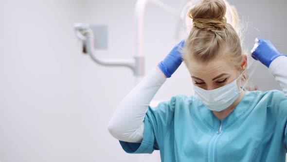 Dentist Putting on Protective Mask Before Surgery alt
