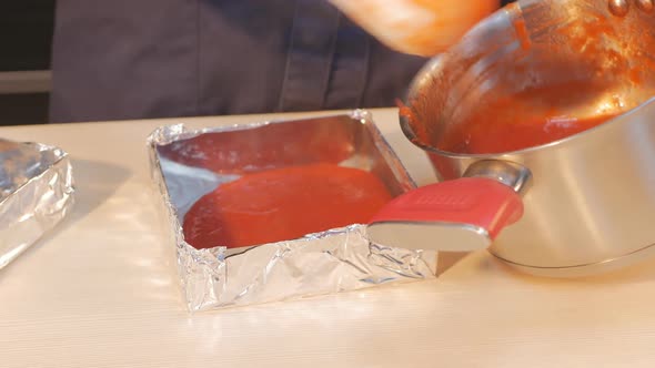 a Woman Confectioner Spoons Hot Berry Confit Into a Mold Wrapped in Foil