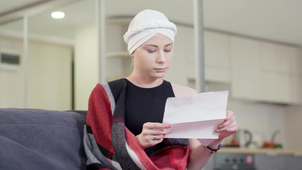 Stressed Upset Young Woman Reading Letter with Bad News Touching Head and Sighing alt