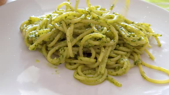 Spaghetti with Pesto Sauce Being Served with a Spaghetti Spoon alt