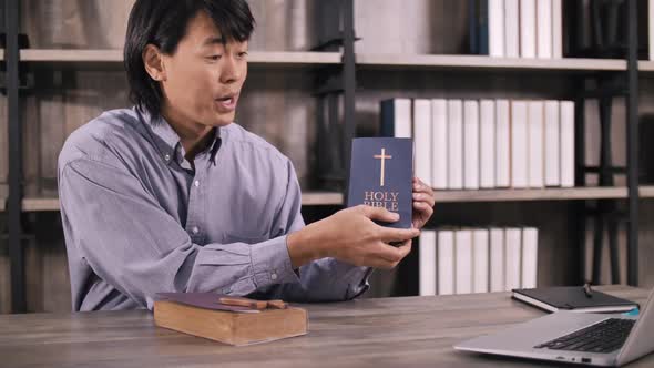 Young missionary is giving his audience the scriptural instruction through videoconferencing. alt