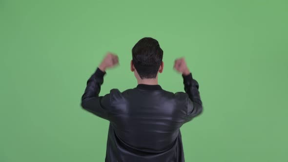 Rear View of Happy Young Multi Ethnic Man with Fists Raised alt