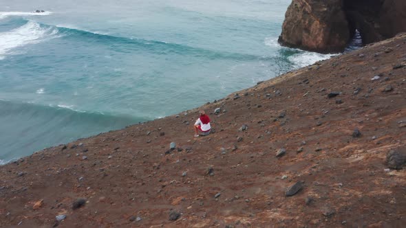Man Looking Ocean Waves Rolling on Volcanic Beach of Faial Island Azores alt