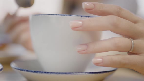 In the Frame Female Hands with a Manicure Women in a Cafe Discussing the Quality of Nails and alt