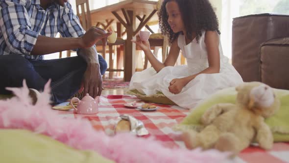 African american father and daughter having picnic at home alt